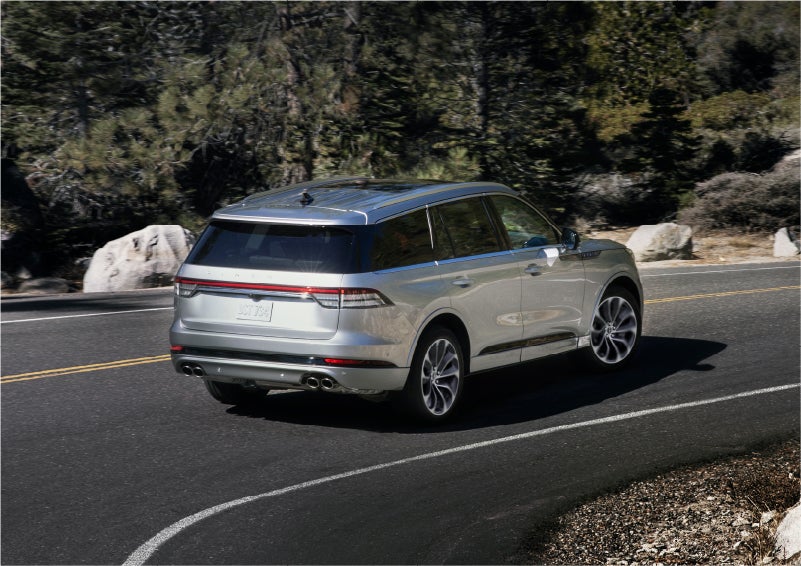 A 2023 Lincoln Aviator® Grand Touring model is shown being driven on a tight turn of a mountain road | Uptown Lincoln in Wauwatosa WI
