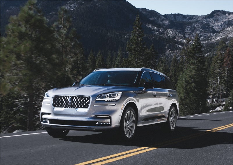 A 2023 Lincoln Aviator® Grand Touring SUV being driven on a winding road to demonstrate the capabilities of all-wheel drive | Uptown Lincoln in Wauwatosa WI