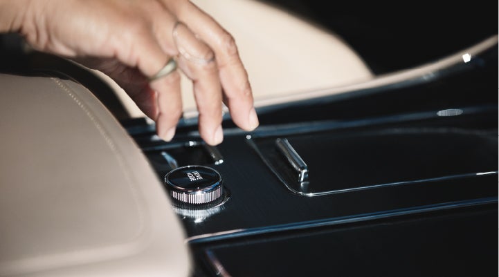 A hand is shown reaching for the Lincoln Drive Modes knob