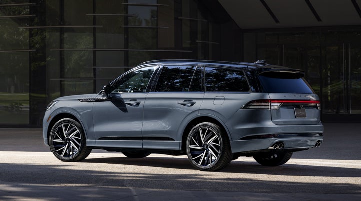 A Whisper Blue 2025 Lincoln Black Label Aviator® SUV is parked outside a modern building. | Uptown Lincoln in Wauwatosa WI