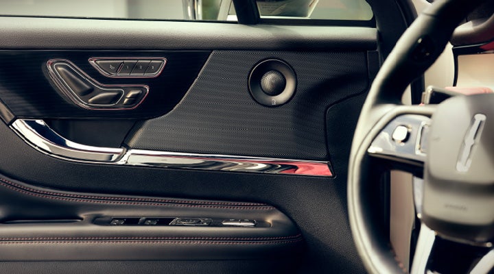 A Revel® audio speaker is shown in the driver's side door of a 2025 Lincoln Corsair® SUV.