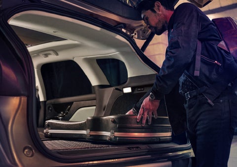 A man is shown loading cargo into the rear of a 2025 Lincoln Corsair® SUV with the second-row seats folded flat.