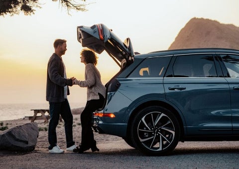 A couple share a moment together outside a 2025 Lincoln Corsair® SUV near the open liftgate. | Uptown Lincoln in Wauwatosa WI