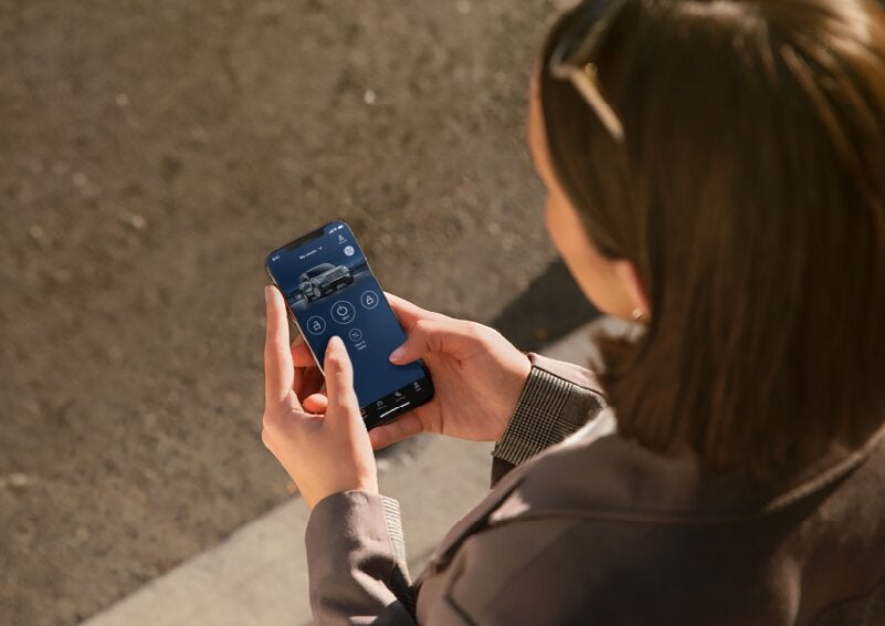 A person is shown interacting with a smartphone to connect to a Lincoln vehicle via the Lincoln Way® App. | Uptown Lincoln in Wauwatosa WI