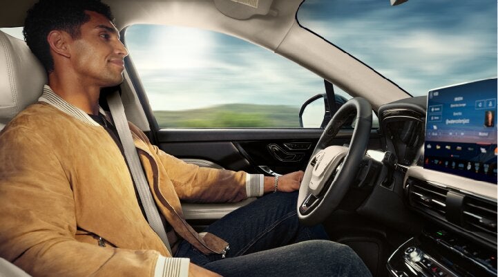 A person is shown using Lincoln BlueCruise hands-free highway driving technology on a divided highway called a Hands-Free Blue Zone. | Uptown Lincoln in Wauwatosa WI