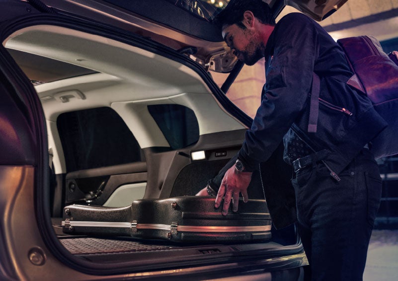 A man is shown loading cargo into the rear of a 2024 Lincoln Corsair® SUV with the second-row seats folded flat. | Uptown Lincoln in Wauwatosa WI