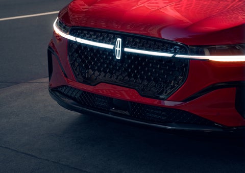 The available front LED light bar and center Lincoln Star logo glow at dusk. | Uptown Lincoln in Wauwatosa WI