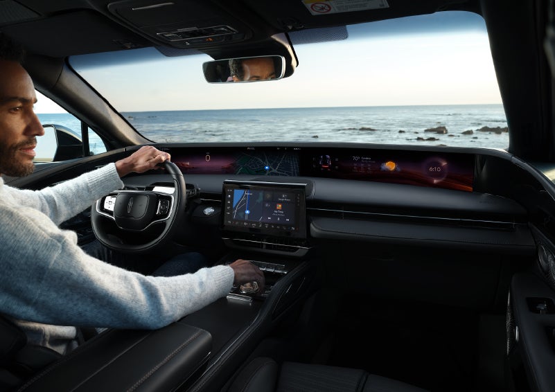A driver of a parked 2025 Lincoln Nautilus® SUV takes a relaxing moment at a seaside overlook while inside his Nautilus. | Uptown Lincoln in Wauwatosa WI
