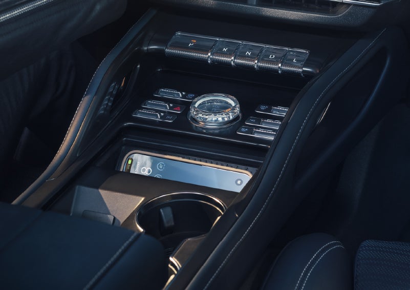 A smartphone is shown charging in the wireless charging pad. | Uptown Lincoln in Wauwatosa WI