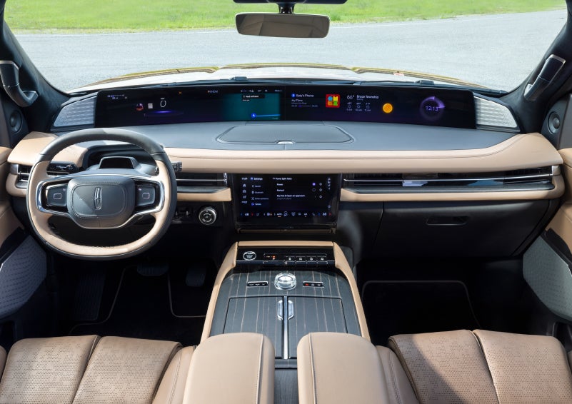 A driver of a 2025 Lincoln Navigator(r) SUV reaches for the center touch screen.