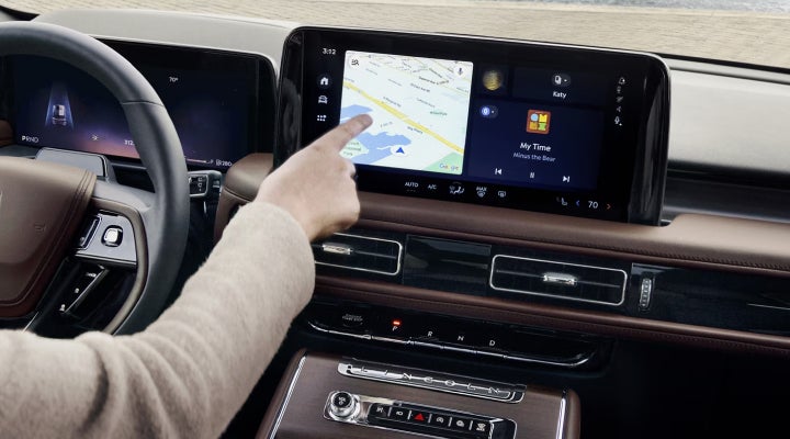 A person is tapping the center display touchscreen of a 2026 Lincoln Aviator® SUV. | Uptown Lincoln in Wauwatosa WI