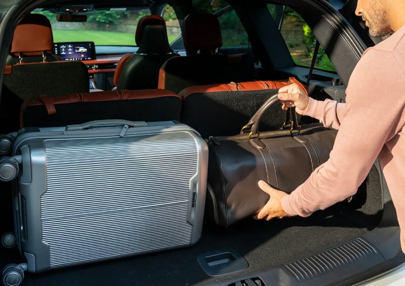 A man loads luggage into the rear of a 2026 Lincoln Aviator® SUV through the opened rear liftgate. | Uptown Lincoln in Wauwatosa WI