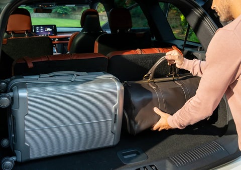 A man loads luggage into the rear of a 2026 Lincoln Aviator® SUV through the opened rear liftgate. | Uptown Lincoln in Wauwatosa WI