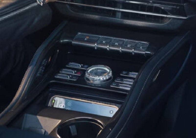 A smartphone is shown charging in the wireless charging pad. | Uptown Lincoln in Wauwatosa WI