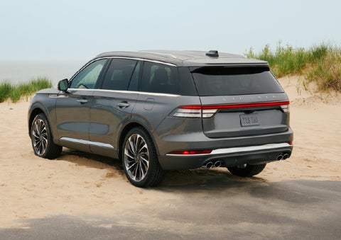 A 2027 Lincoln Aviator® SUV is parked next to sand dunes. | Uptown Lincoln in Wauwatosa WI