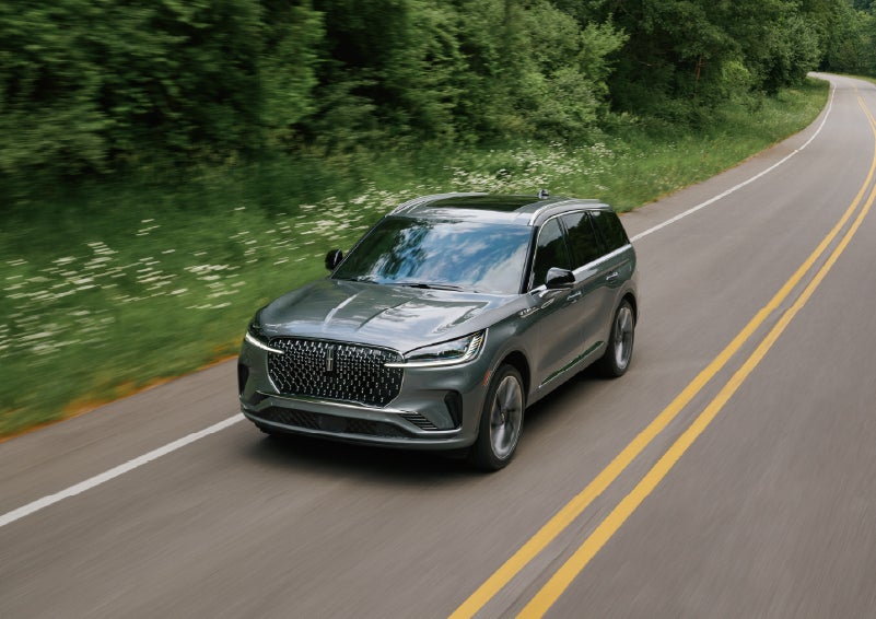 A 2027 Lincoln Aviator® SUV is being driven down a road. | Uptown Lincoln in Wauwatosa WI