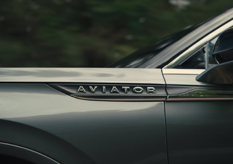 The driver’s side door and fender badging of a gray 2027 Lincoln Aviator® SUV are showcased. | Uptown Lincoln in Wauwatosa WI