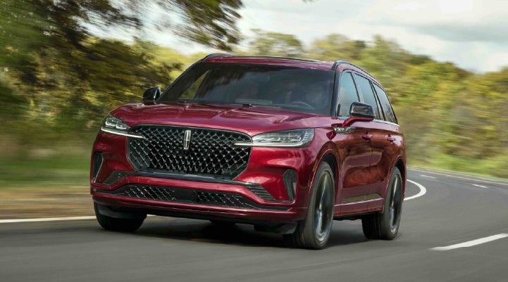 A 2027 Lincoln Aviator® SUV is being driven on a country road | Uptown Lincoln in Wauwatosa WI