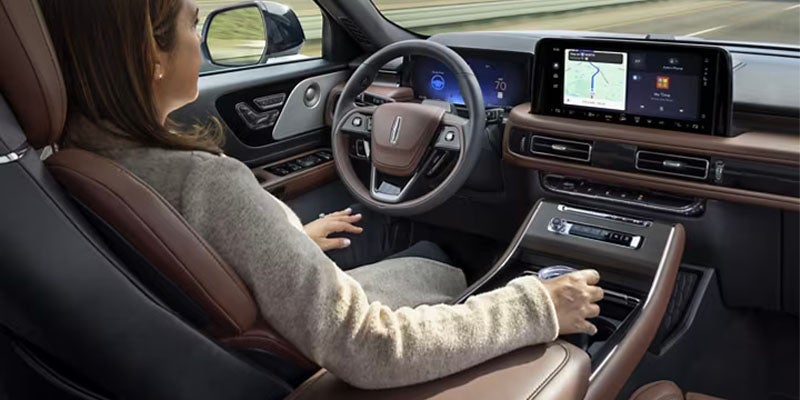 Lincoln Navigator interior featuring brown leather seats, a multifunction steering wheel, digital instrument cluster